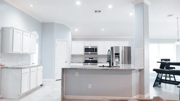 a kitchen with stainless steel appliances kitchen island granite countertop a sink and cabinets