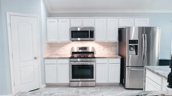 a kitchen with cabinets stainless steel appliances and a counter space