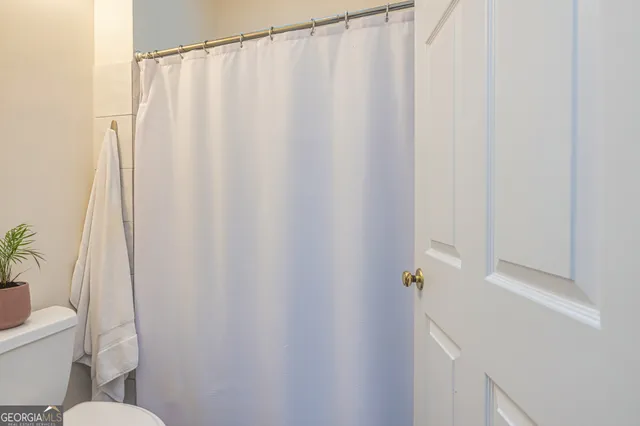 a white toilet sitting next to a shower