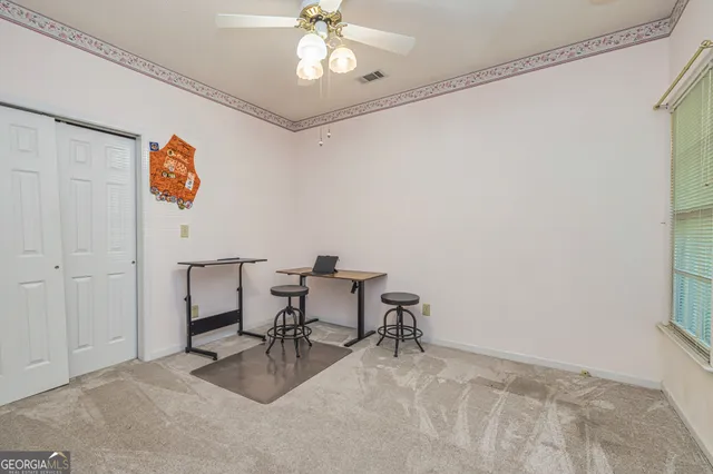 a view of a workspace with furniture and a window