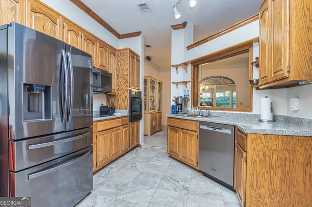 a kitchen with stainless steel appliances granite countertop a refrigerator and a sink