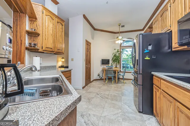 a kitchen with granite countertop a sink and a refrigerator