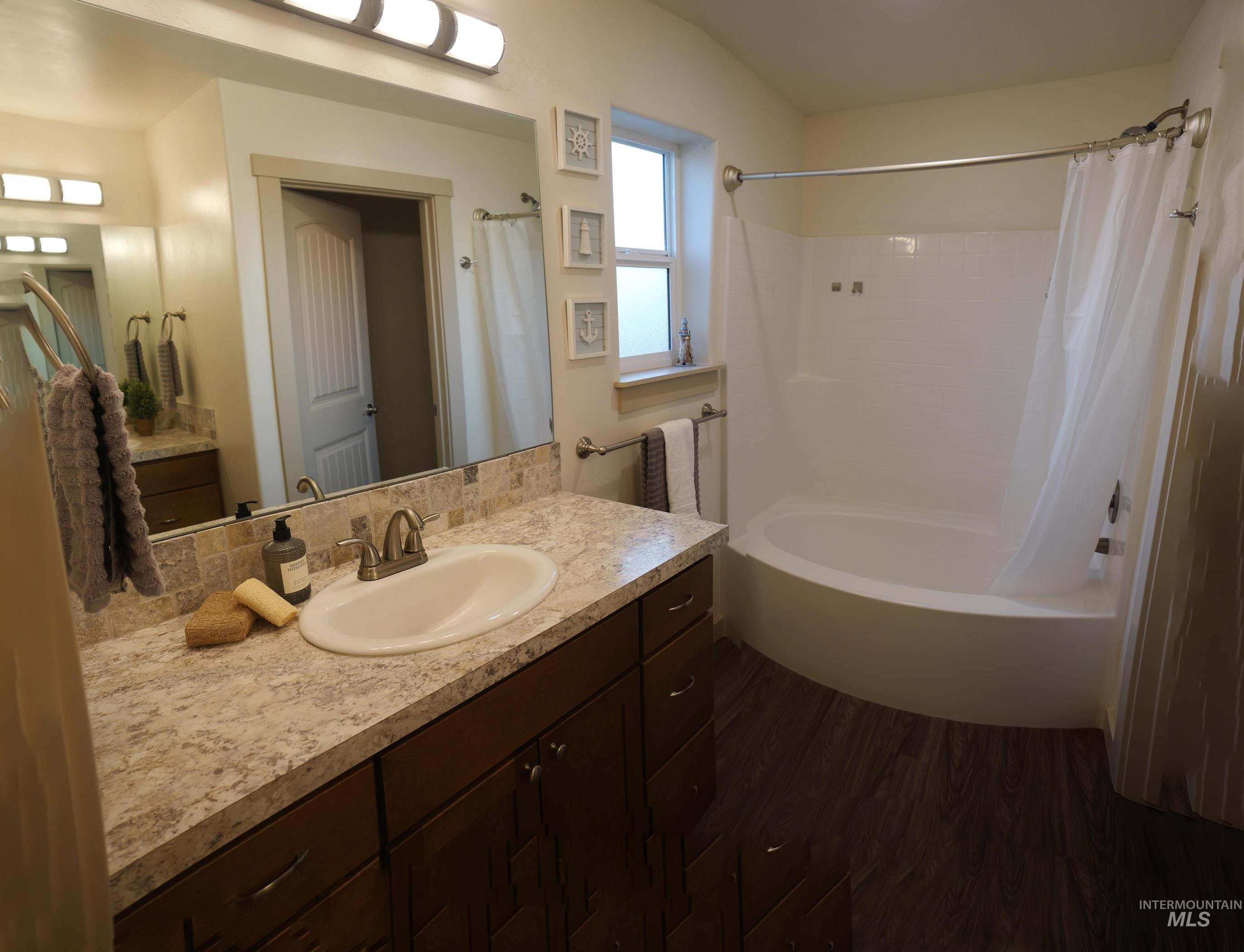 178 Syringa Loop Shoshone, ID 83352 - Photo 17 of 35 Bathroom featuring a vanity with dark wood-finish cabinetry, a light-toned countertop, and a built-in sink