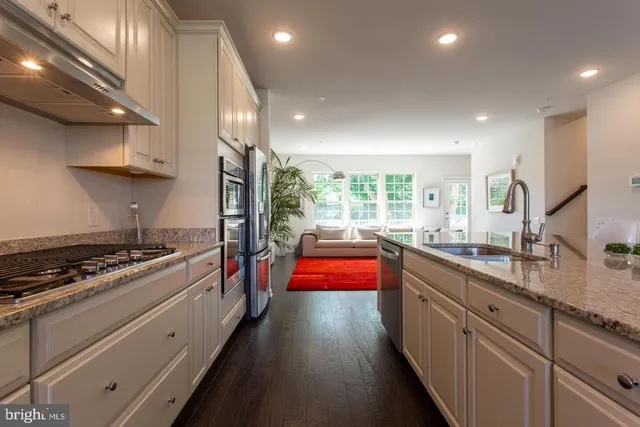a kitchen with stainless steel appliances granite countertop sink stove and refrigerator
