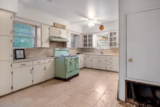 a kitchen with cabinets appliances and a window