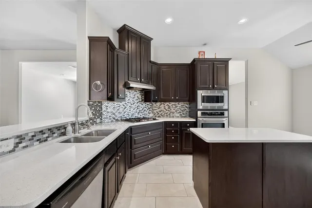a kitchen with stainless steel appliances granite countertop a refrigerator and a stove