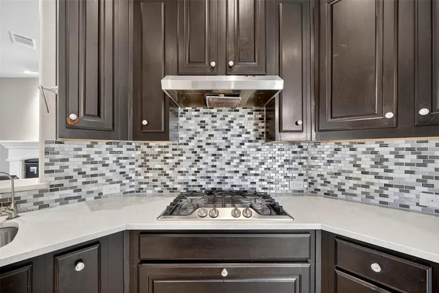 a kitchen with a stove and white cabinets