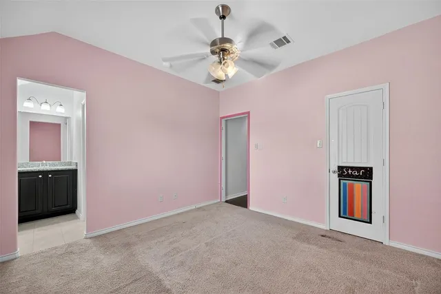 an empty room with a ceiling fan and windows