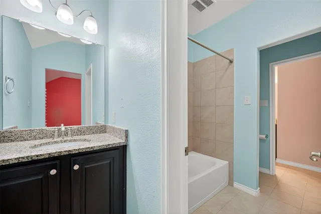 a bathroom with a granite countertop double vanity sink and a mirror