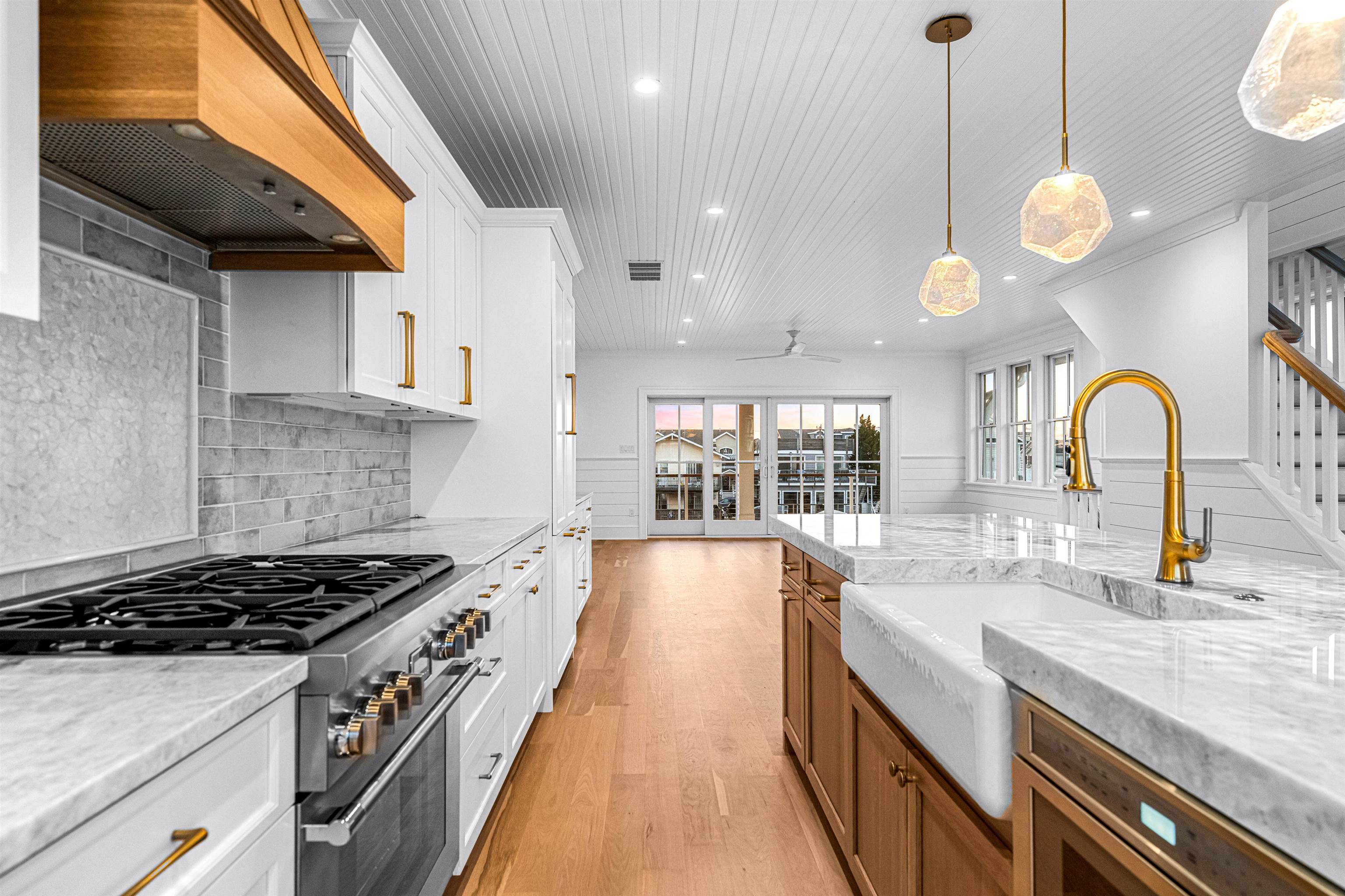 2148 Ocean, Unit 2148 Avalon, NJ 08202 - Photo 20 of 40 a large kitchen with stainless steel appliances granite countertop a stove a sink a dining table and chairs with wooden floor
