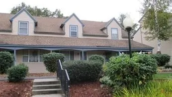 a front view of a house with a yard and trees