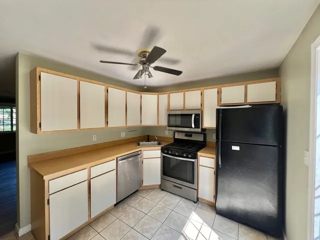 a kitchen with stainless steel appliances granite countertop a refrigerator a stove a sink and a refrigerator