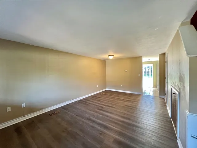 an empty room with window and wooden floor