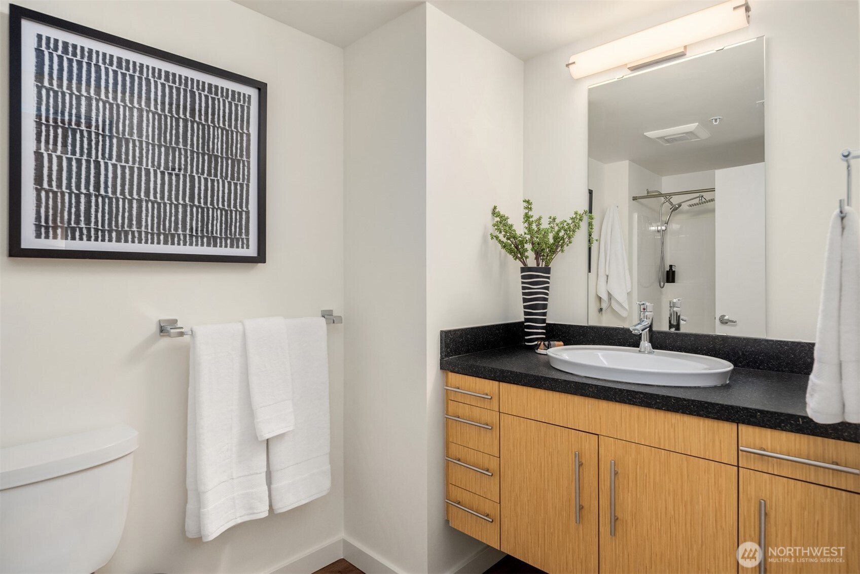 401 9th Avenue North, Unit 210 Seattle, WA 98109 - Photo 6 of 30 a bathroom with a granite countertop sink and a mirror