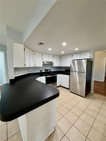 a kitchen with stainless steel appliances granite countertop a refrigerator a sink and a stove