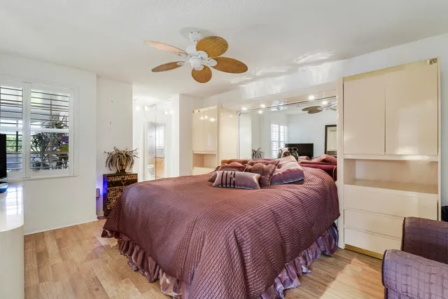 a bathroom with a granite countertop sink a toilet a mirror and shower