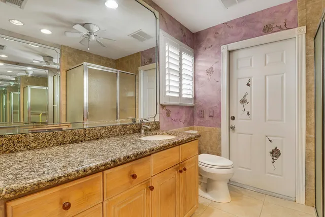 a bathroom with a granite countertop sink toilet and shower
