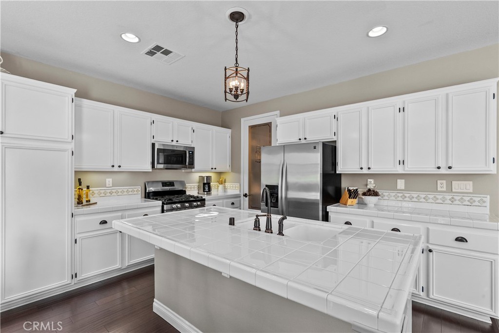 28409 Connick Place Saugus, CA 91350 - Photo 18 of 66 a kitchen with stainless steel appliances a sink a stove a refrigerator cabinets and a window
