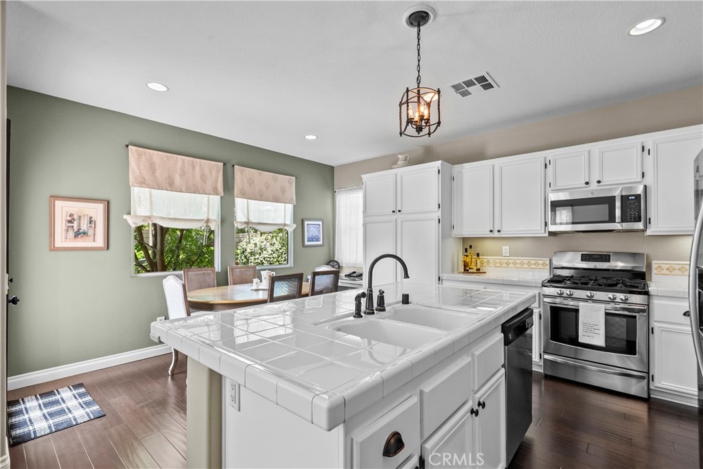 28409 Connick Place Saugus, CA 91350 - Photo 19 of 66 a kitchen with stainless steel appliances granite countertop a sink a stove a refrigerator cabinets and a window
