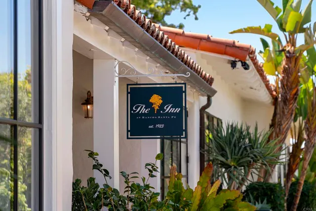 a vase with flowers sitting on a bookshelf next to a yard