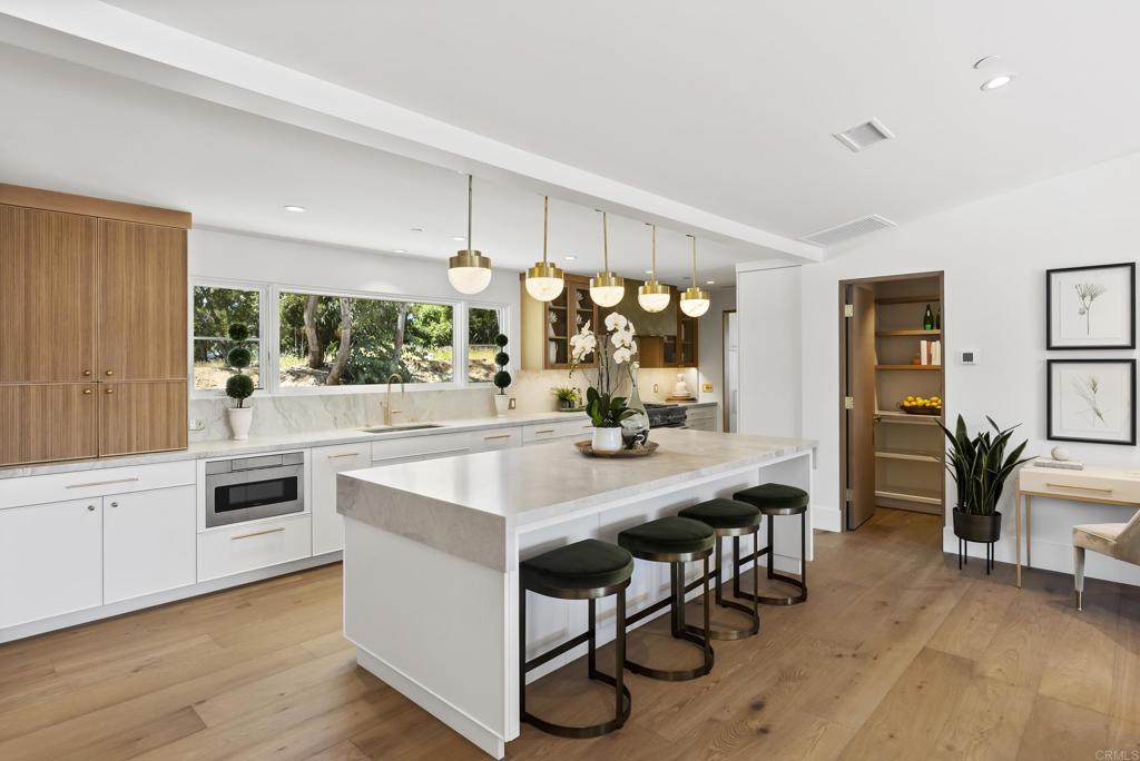 5927 Linea Del Cielo, Unit ELM Rancho Santa Fe, CA 92067 - Photo 7 of 20 a kitchen with stainless steel appliances a table and chairs in it