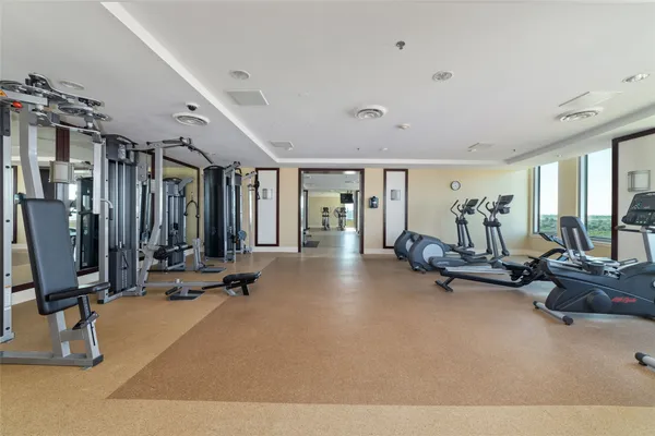 a room with gym equipment and large mirror
