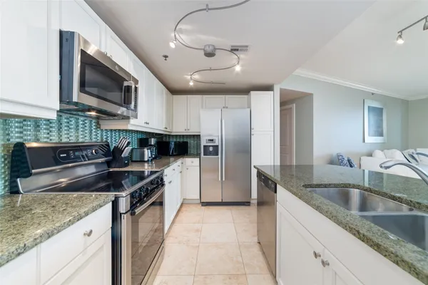 a kitchen with stainless steel appliances granite countertop a sink and a microwave