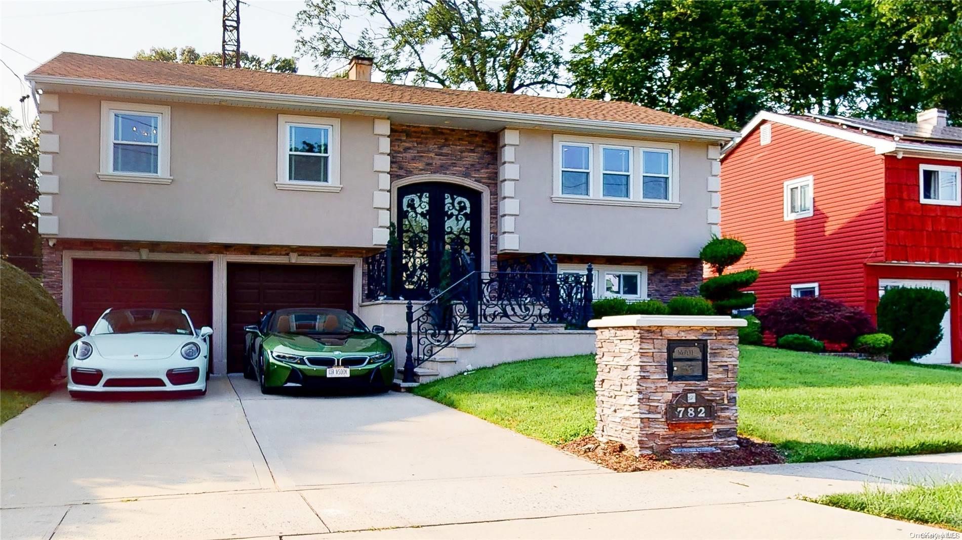 782 Iris Place West Hempstead, NY 11552 - Photo 1 of 1 a front view of a house with a garden and trees