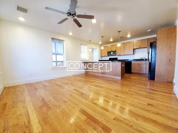 a large kitchen with stainless steel appliances kitchen island granite countertop a sink cabinets and wooden floor
