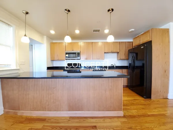 a kitchen with stainless steel appliances granite countertop a refrigerator a sink and a stove