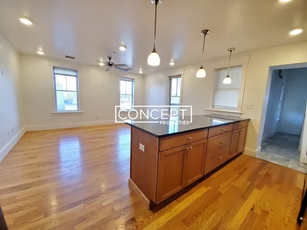 a kitchen with stainless steel appliances granite countertop wooden cabinets a sink dishwasher a dining table and chairs
