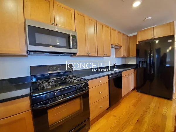a kitchen with stainless steel appliances granite countertop a stove a sink and a microwave