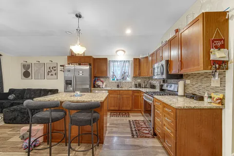 a kitchen with stainless steel appliances granite countertop a sink a stove and a refrigerator