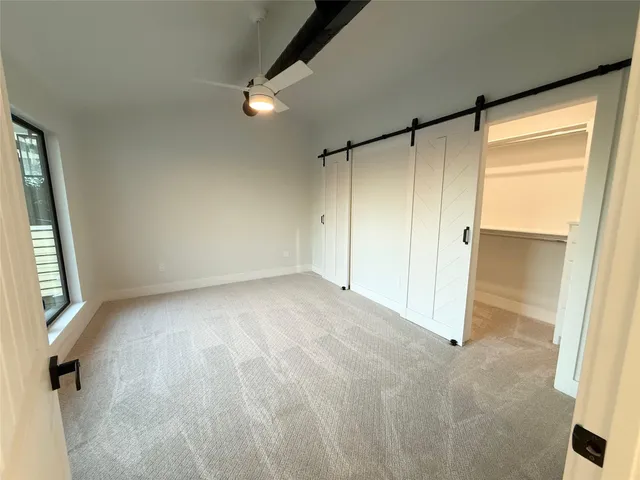 an empty room with a cabinet and a refrigerator