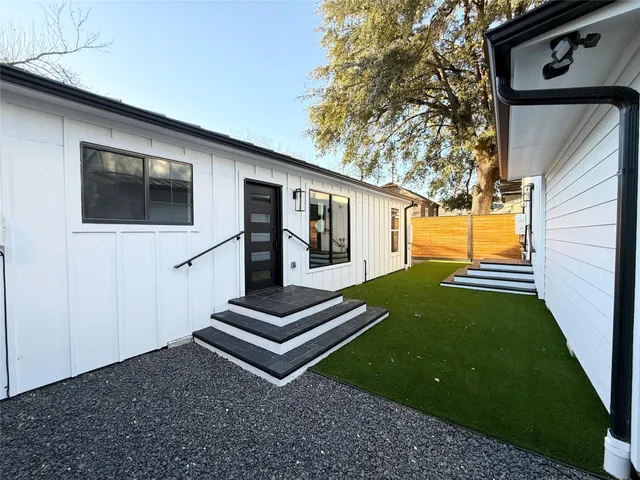 a kitchen with a refrigerator a stove cabinets dining table and chairs