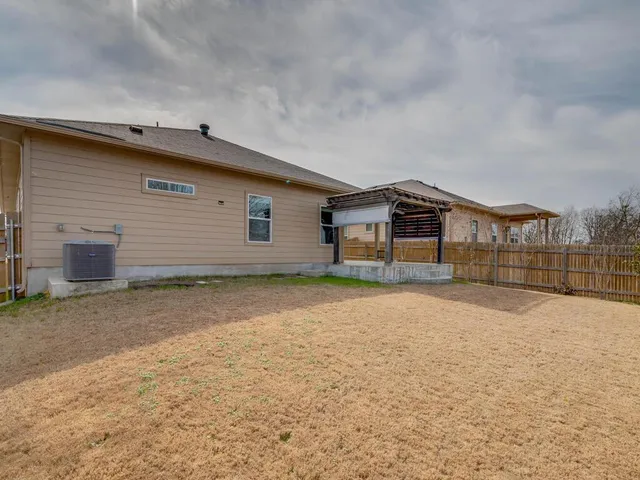 a view of a house with a yard and a large tree