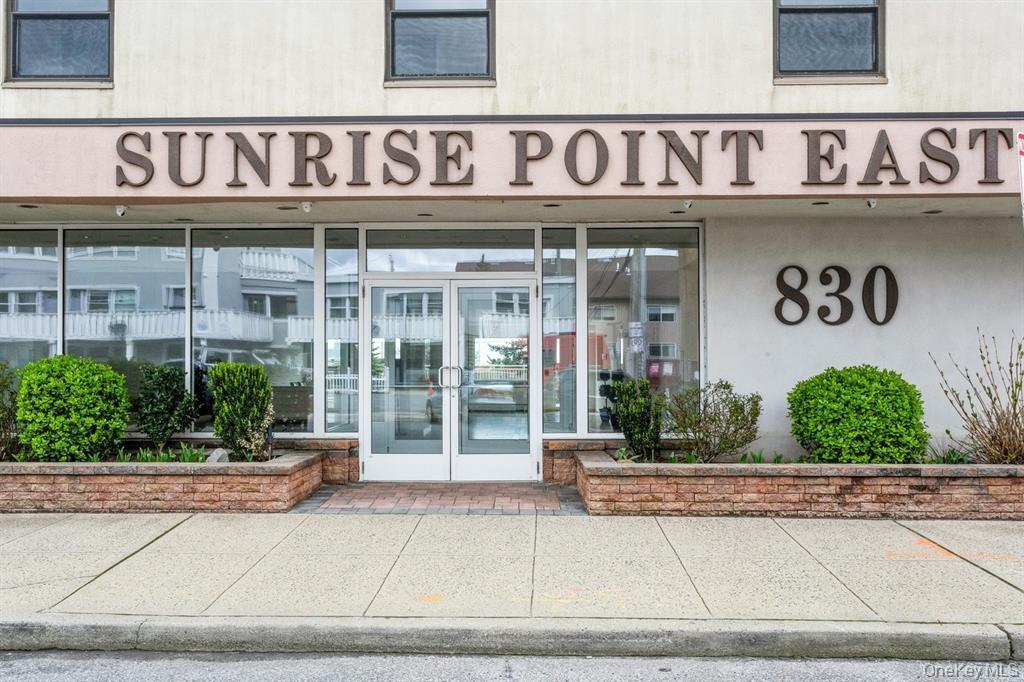 830 Shore Road, Unit 4Q Long Beach, NY 11561 - Photo 1 of 26 a front view of a building with retail windows and plants