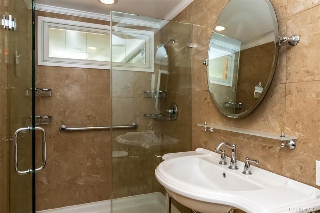 830 Shore Road, Unit 4Q Long Beach, NY 11561 - Photo 5 of 26 a bathroom with a sink and shower