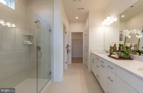 a bathroom with a double vanity sink mirror and shower