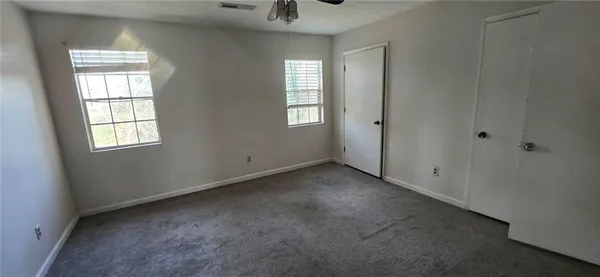 an empty room with windows and closet