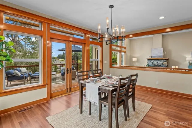 a dining room with furniture a chandelier and wooden floor