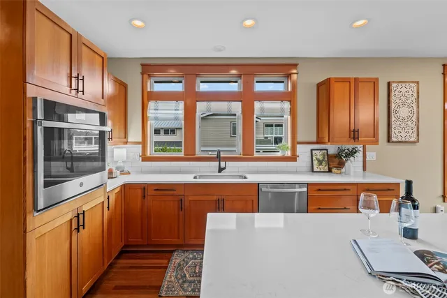a large kitchen with stainless steel appliances granite countertop a large window and a counter space