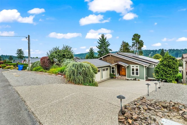 a front view of a house with a yard and potted plants