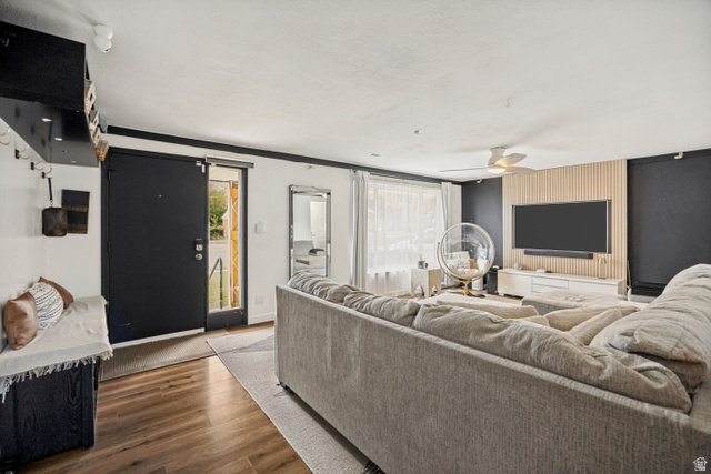 1215 8th Street Ogden, UT 84404 - Photo 7 of 39 Open-concept living space featuring wood-finish flooring, a contemporary ceiling fan, and an accent wall with vertical wood paneling