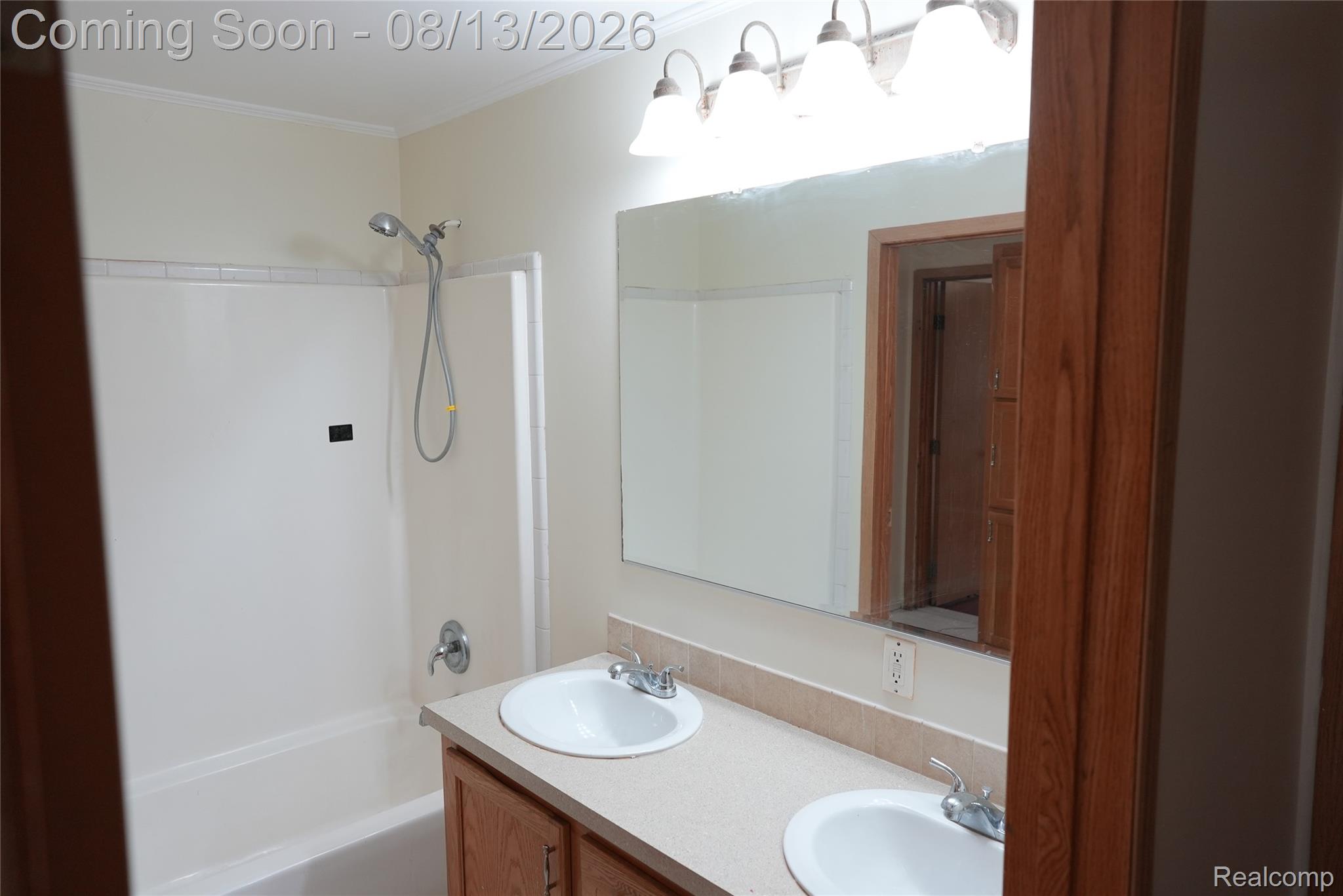 2018 John R Road Troy, MI 48083 - Photo 40 of 57 Double vanity with integrated sinks, wood-finish cabinetry, and a full-width mirror