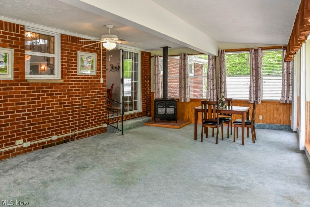 4877 4th Street Northwest Canton, OH 44708 - Photo 10 of 24 The 4-seasons room boasts a gas pot belly stove and sliding glass doors.