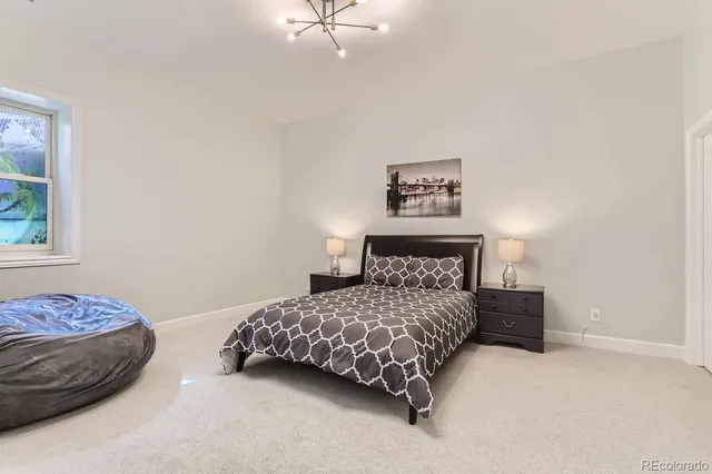 a bedroom with a bed and a lamp on dresser