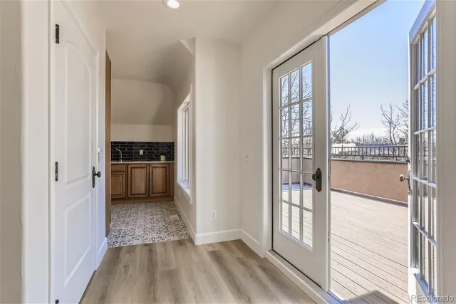 a view of a kitchen from the hallway with a large window and refrigerator