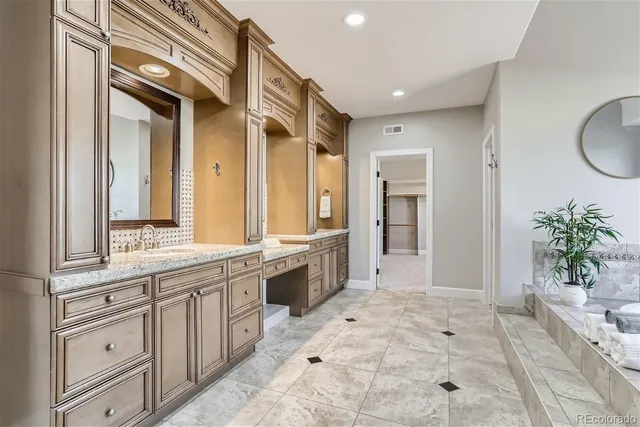 a spacious bathroom with a granite countertop sink a mirror and a bathtub