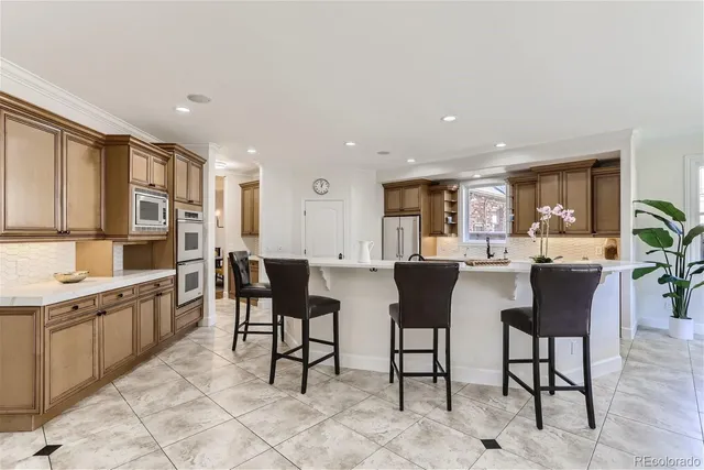 a open kitchen with stainless steel appliances kitchen island granite countertop a table and chairs in it